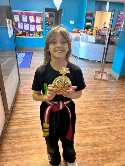 Yon timoun k ap souri nan yon inifòm karate