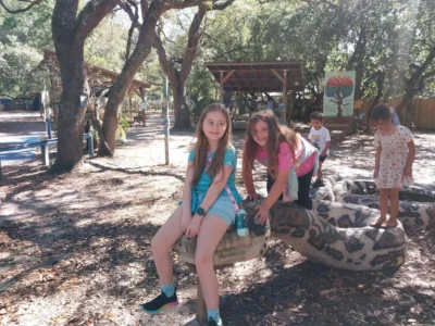 Timoun yo ap jwe sou yon gwo eskilti ki gen fòm koulèv.